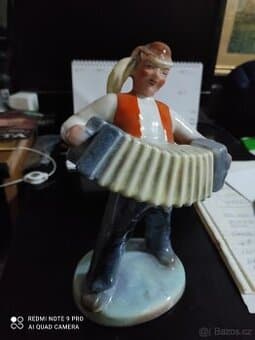 Porcelánová soška harmonikář
